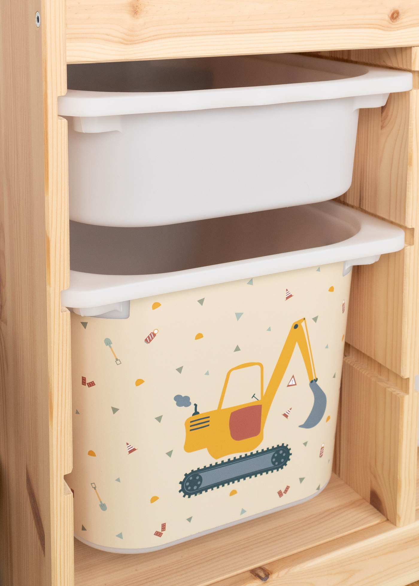 Bagger-Aufbewahrungsbox im TROFAST Regal Kinderfreundliches Bagger-Motiv auf beiger IKEA TROFAST Aufbewahrungsbox.