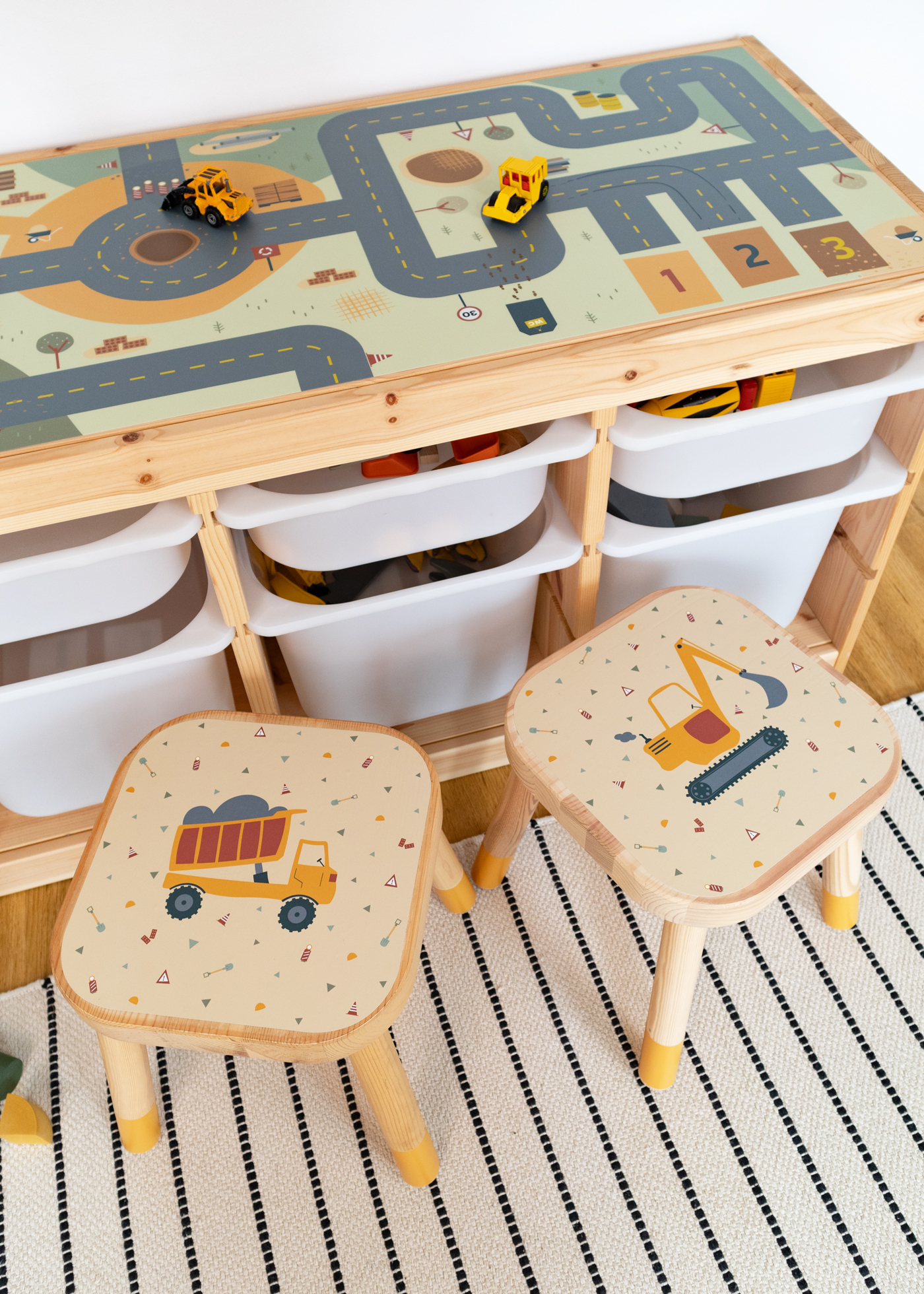 Baustellenmotive für die IKEA FLISAT Stühle Zwei IKEA FLISAT Kinderhocker mit Klebfolien von Limmaland mit Baustellenmotiven stehen vor einem IKEA Trofast Regal mit Limmaland Spielstraße