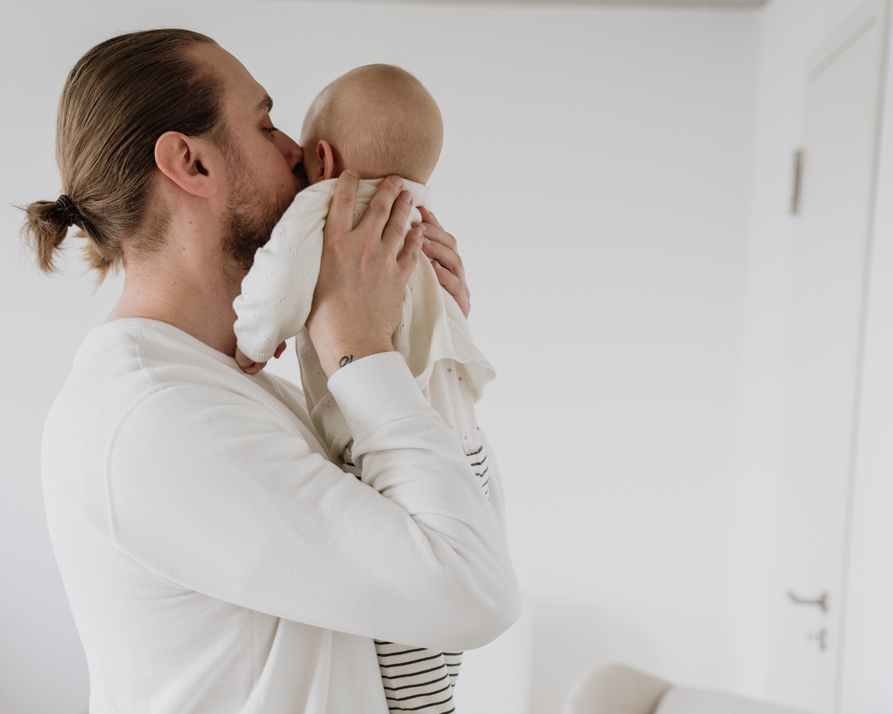 Papa umarmt Baby im Babyzimmer Papa umarmt Baby im Babyzimmer