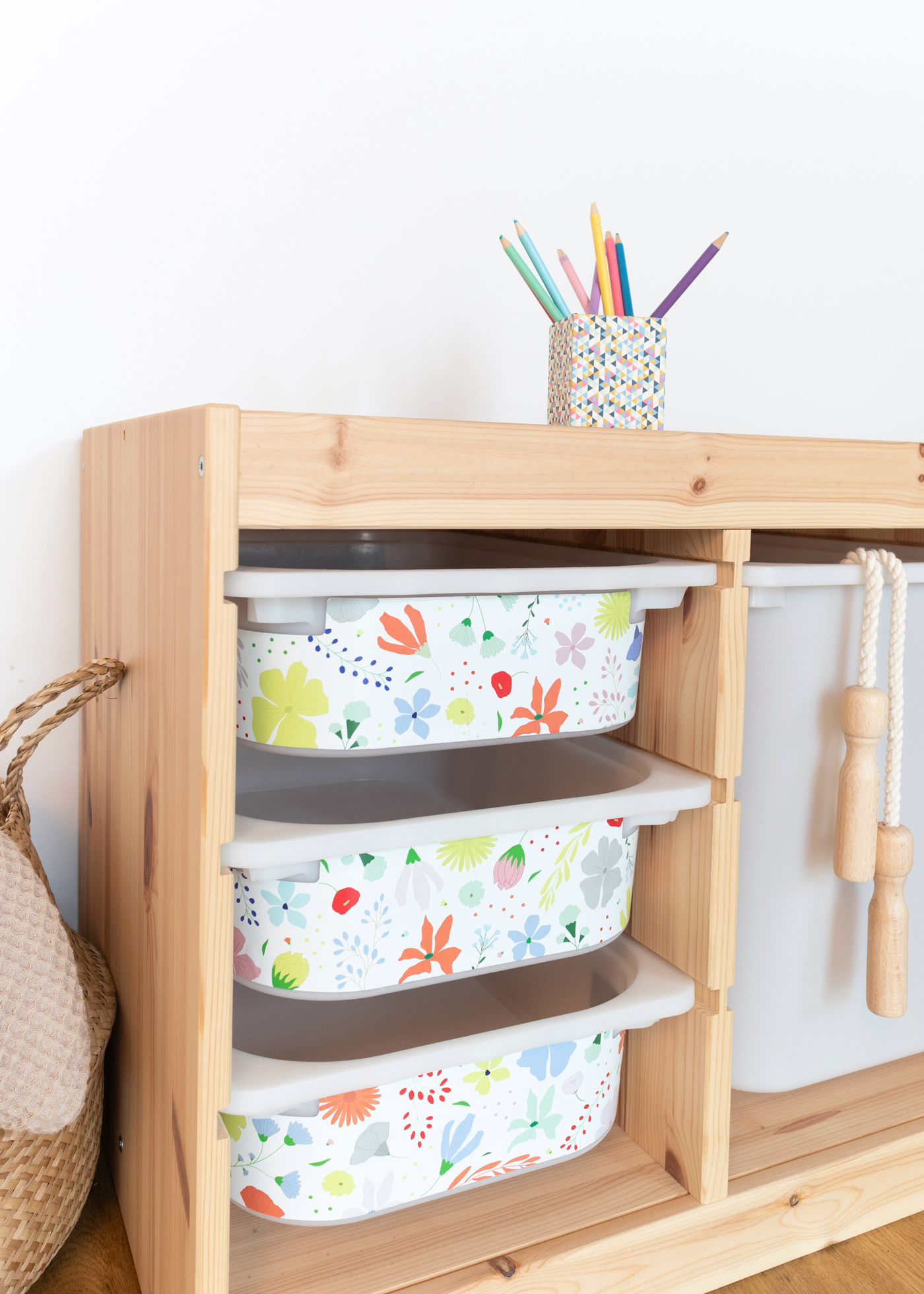 Klebefolie mit Blumenmuster für IKEA TROFAST Box Ein IKEA TROFAST Regal im Raum, beklebt mit einer farbenfrohen Folie mit Blumenmotiven.