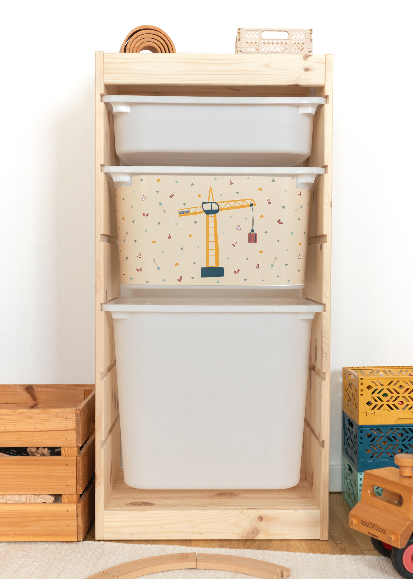 Kran-Motiv auf Kinderaufbewahrungsbox im TROFAST Regal Beige Aufbewahrungsbox im IKEA TROFAST Regal mit dekorativem Kran-Motiv.